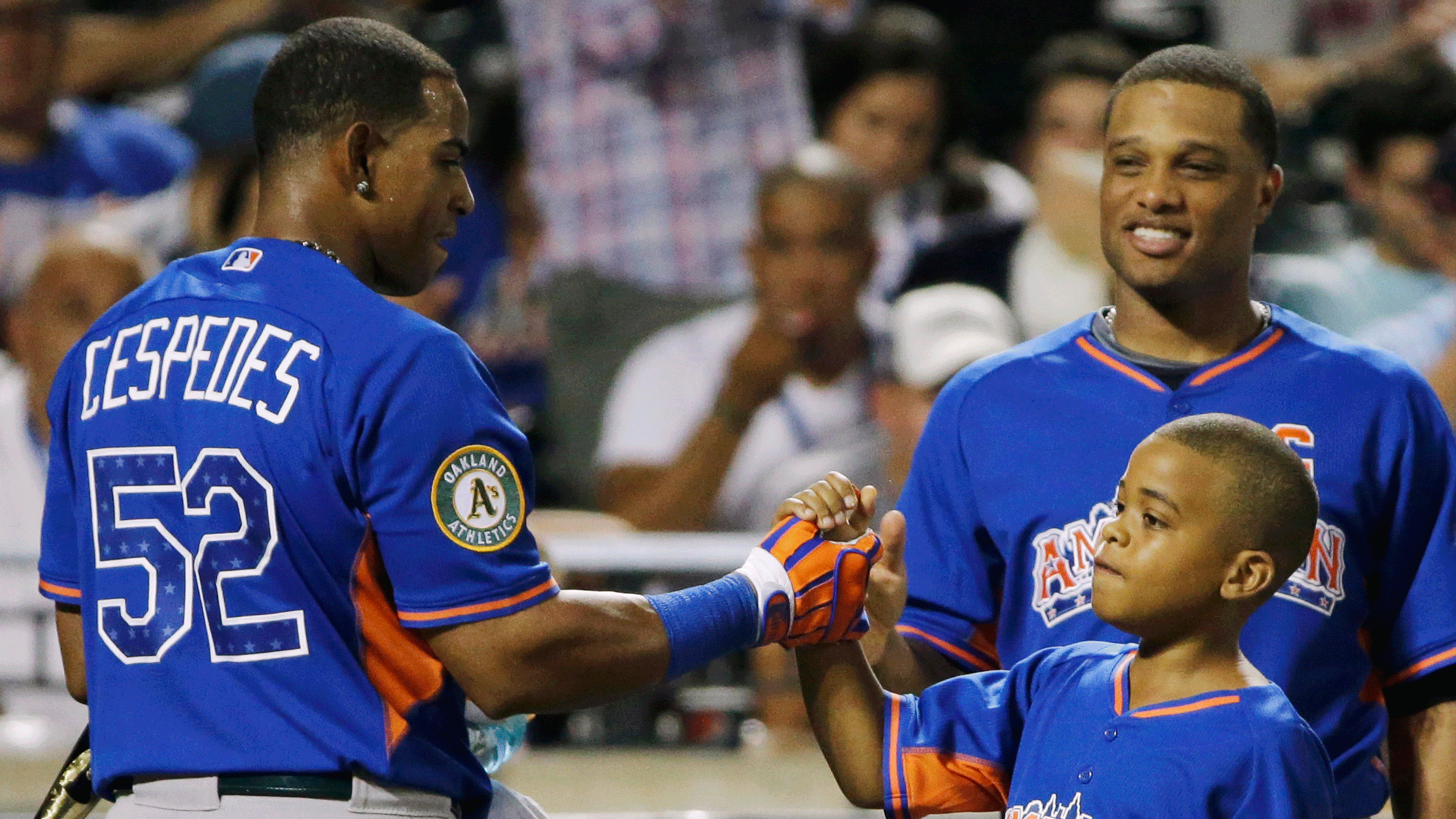 Yoenis Cespedes is greeted by a child and Robinson Cano. (AP/Matt Slocum)