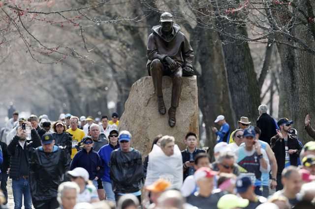 Runners who were diverted from the race course walk on the Commonwealth Mall two blocks from the site of an explosion at the finish line of the Boston Marathon in Boston, Monday, April 15, 2013. Two bombs exploded near the finish line of the Boston Marathon on Monday, killing at least two people and injuring at least 23 others. (AP Photo/Michael Dwyer)