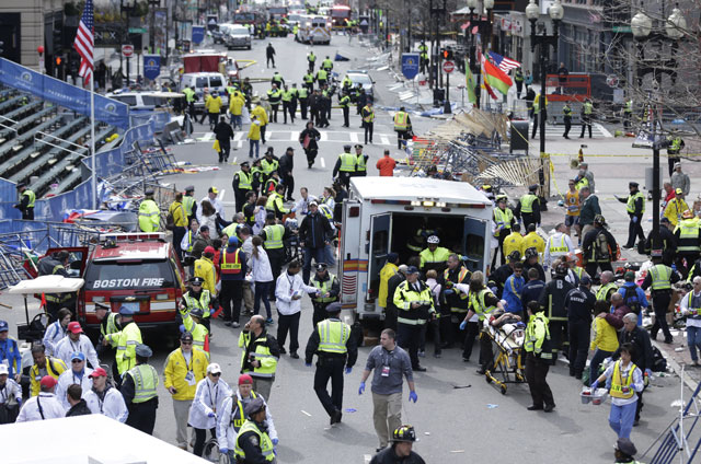 Medical workers aid injured people at the finish line of the 2013 Boston Marathon following an explosion in Boston, Monday, April 15, 2013. (AP Photo/Charles Krupa)