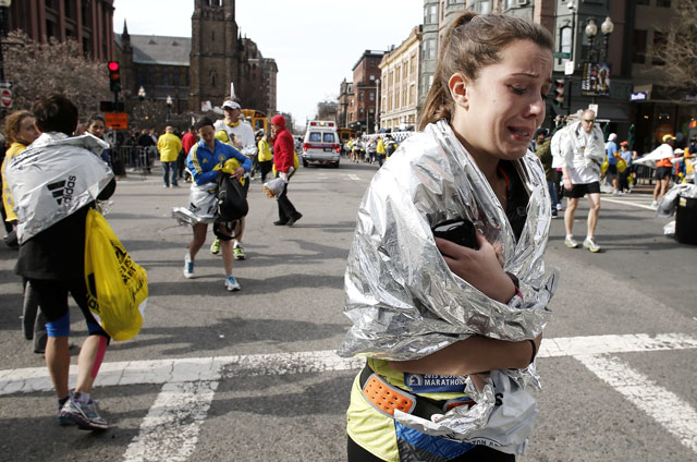 An unidentified Boston Marathon runner leaves the course crying near Copley Square following an explosion in Boston Monday, April 15, 2013. (AP Photo/Winslow Townson)