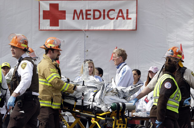 Medical personnel work outside the medical tent in the aftermath of two blasts which exploded near the finish line of the Boston Marathon in Boston, Monday, April 15, 2013. (AP Photo/Elise Amendola) 