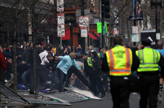 People react to an explosion at the 2013 Boston Marathon in Boston, Monday, April 15, 2013. Two explosions shattered the euphoria of the Boston Marathon finish line on Monday, sending authorities out on the course to carry off the injured while the stragglers were rerouted away from the smoking site of the blasts. (AP Photo/The Daily Free Press, Kenshin Okubo)