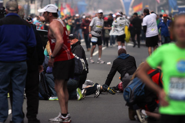 People react to an explosion at the 2013 Boston Marathon in Boston, Monday, April 15, 2013. Two explosions shattered the euphoria of the Boston Marathon finish line on Monday, sending authorities out on the course to carry off the injured while the stragglers were rerouted away from the smoking site of the blasts. (AP Photo/The Daily Free Press, Kenshin Okubo)