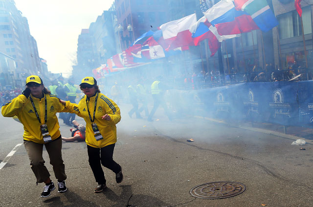 Medical workers aid injured people at the finish line of the 2013 Boston Marathon following an explosion in Boston, Monday, April 15, 2013. (AP Photo/Charles Krupa)