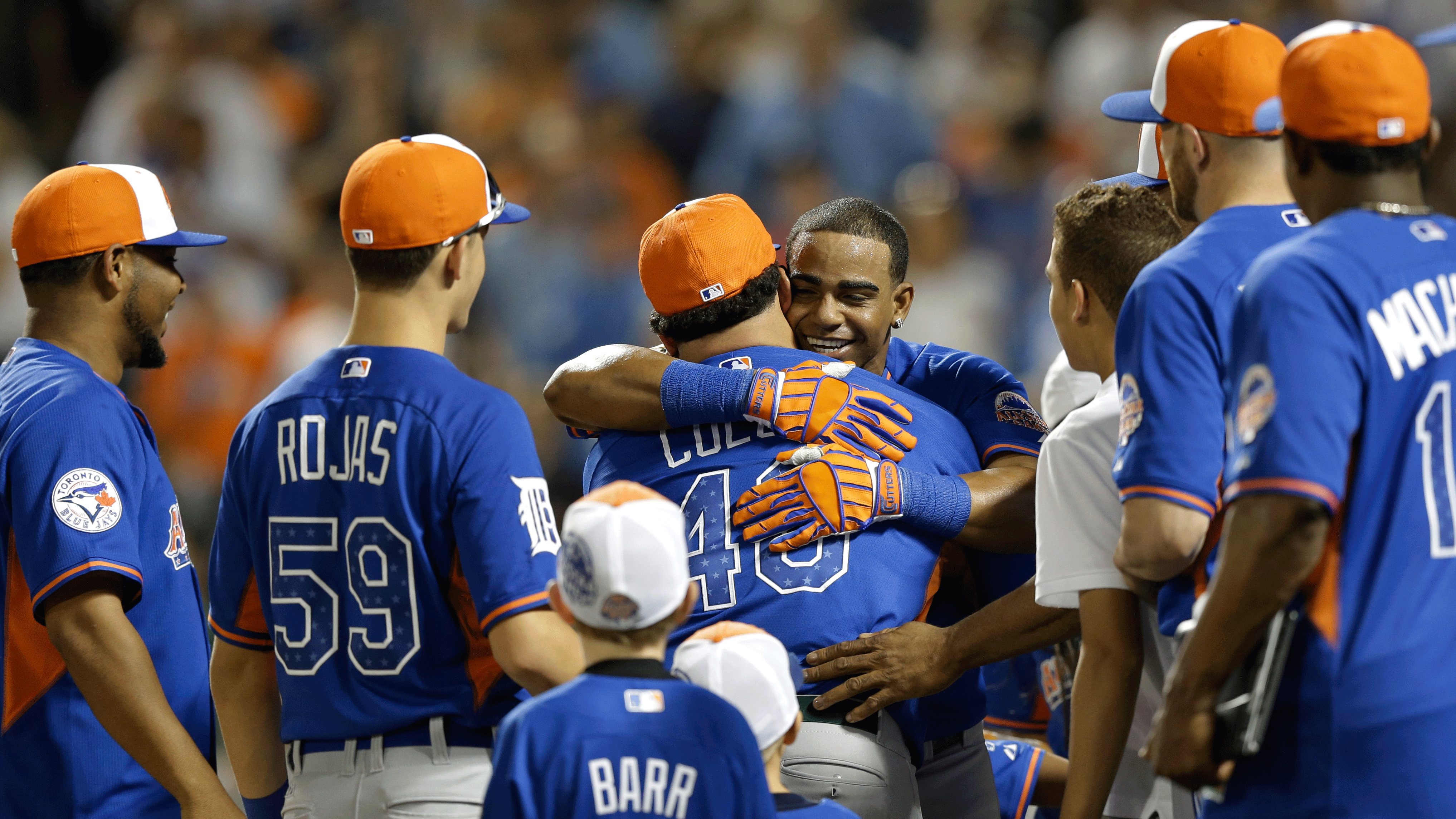 Yoenis Cespedes hugs teammate Bartolo Colon, as fellow AL All-Stars wait to congratulate him on winning the Home Run Derby. (AP/Kathy Willens)