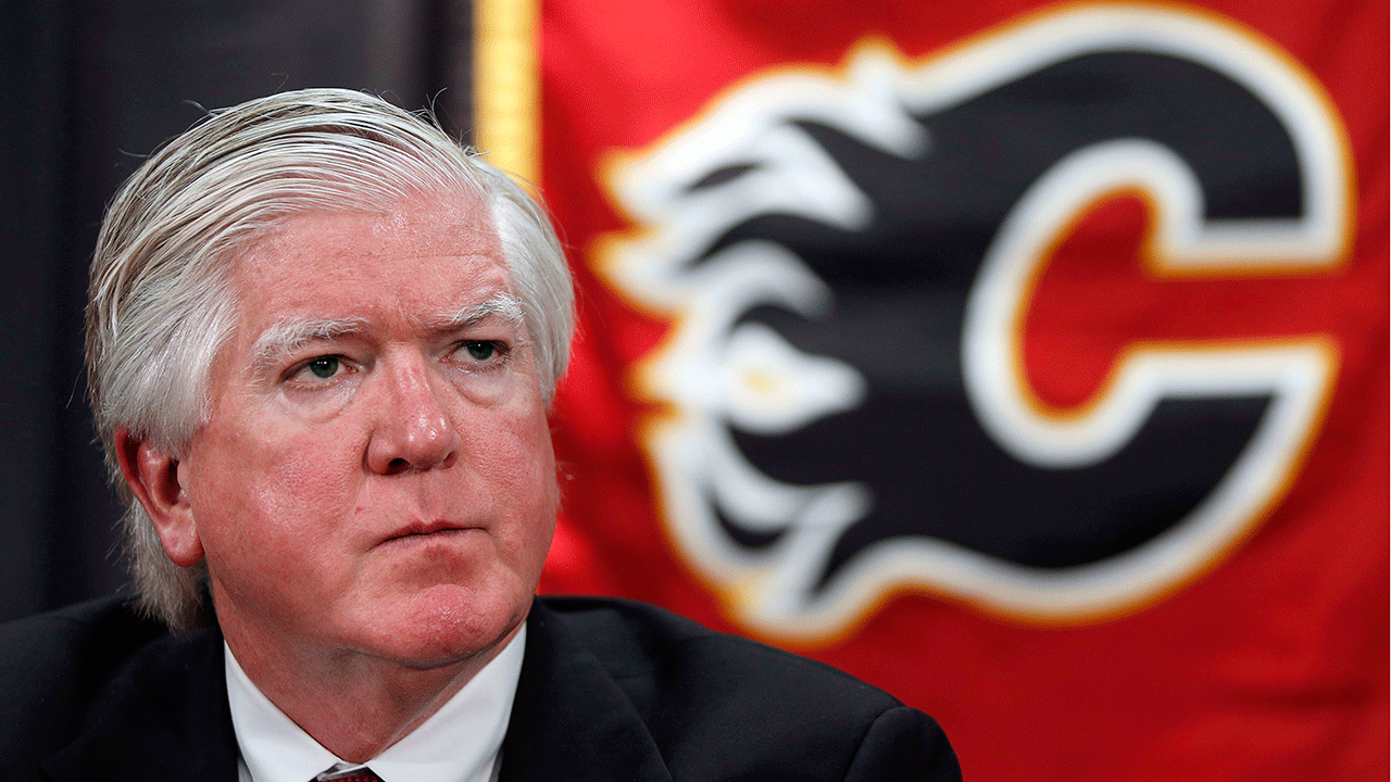 Brian-Burke-sits-at-the-podium-during-a-Calgary-Flames-press-conference