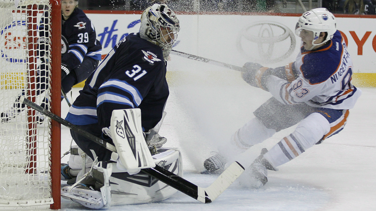 Winnipeg-Jets'-goaltender-Ondrej-Pavelec-(31)-stops-the-shot-from-Edmonton-Oilers'-Ryan-Nugent-Hopkins-(93)-as-Tobias-Enstrom-(39)-looks-on-during-second-period-NHL-action-in-Winnipeg-on-Saturday,-January-18,-2014.-THE-CANADIAN-PRESS/John-Woods