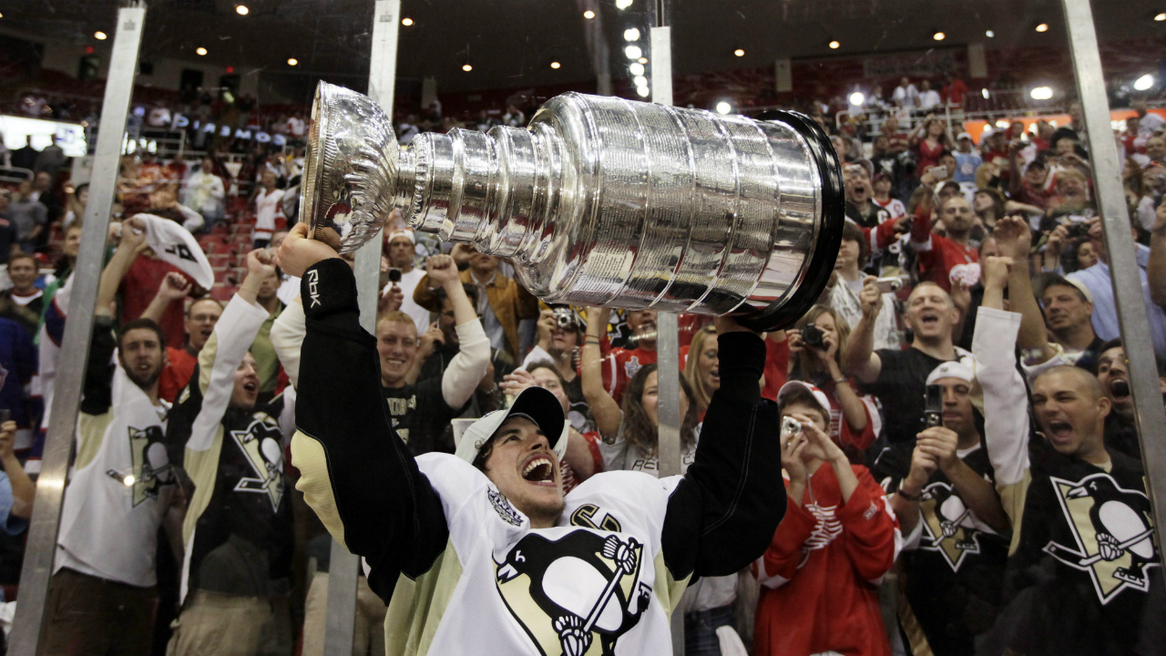 In-this-June-12,-2009,-file-photo,-Pittsburgh-Penguins'-captain-Sidney-Crosby-holds-up-the-Stanley-Cup-after-the-Penguins-beat-the-Detroit-Red-Wings-2-1-to-win-Game-7-of-the-NHL-hockey-Stanley-Cup-finals-in-Detroit.-Wayne-Gretzky-was-"The-Great-One"-and-Mario-Lemieux-was-"The-Magnificent-One."The-hockey-world-is-always-looking-for-a-new-superstar-to-transcend-the-sport.-Eric-Lindros,-Sidney-Crosby-and-John-Tavares-were-dubbed-"The-Next-One"-as-teenagers.-(AP-Photo/Paul-Sancya,-File)