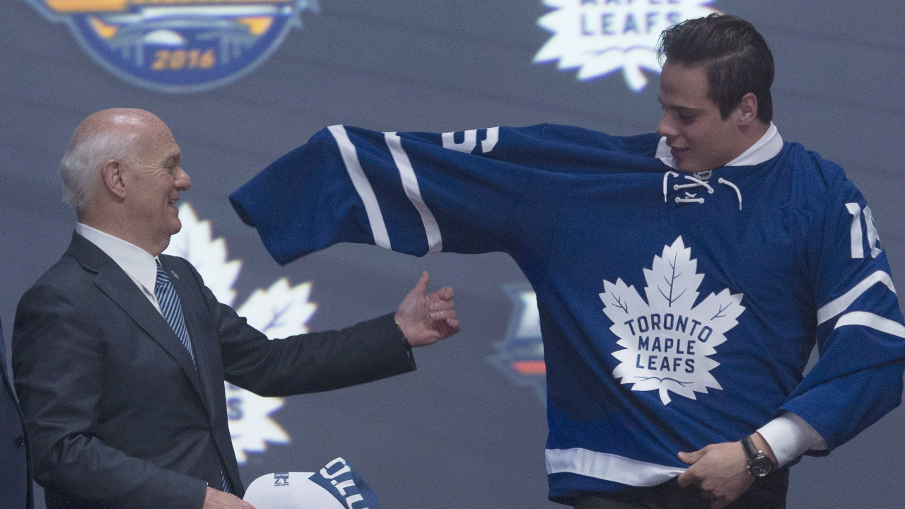 Toronto-Maple-Leafs-general-manager-Lou-Lamoriello-helps-first-overall-pick-Auston-Matthews-as-he-puts-on-his-sweater-at-the-NHL-draft-in-Buffalo,-N.Y.-on-Friday-June-24,-2016.-THE-CANADIAN-PRESS/Nathan-Denette