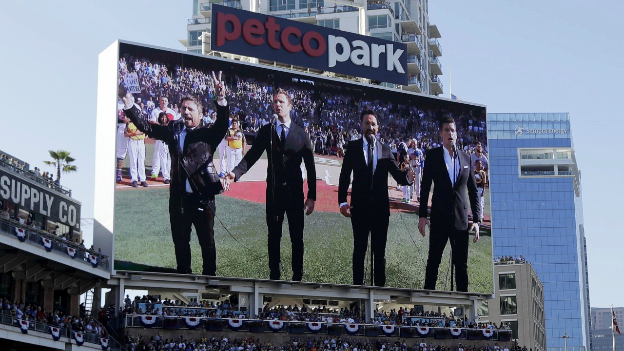 FILE---In-this-Tuesday,-July-12,-2016-file-photo,-The-Tenors,-shown-on-the-scoreboard,-perform-during-the-Canadian-National-Anthem-prior-to-the-MLB-baseball-All-Star-Game,-in-San-Diego.-A-member-of-a-Canadian-singing-quartet-changed-a-lyric-in-his-country's-national-anthem-and-held-up-a-sign-proclaiming-"All-Lives-Matter"-during-a-pregame-performance-at-the-87th-All-Star-Game-on-Tuesday.-The-Tenors,-a-group-based-in-British-Columbia,-caused-a-stir-at-Petco-Park-with-Remigio-Pereira's-actions-while-singing-"O-Canada."-(AP-Photo/Gregory-Bull,-File)