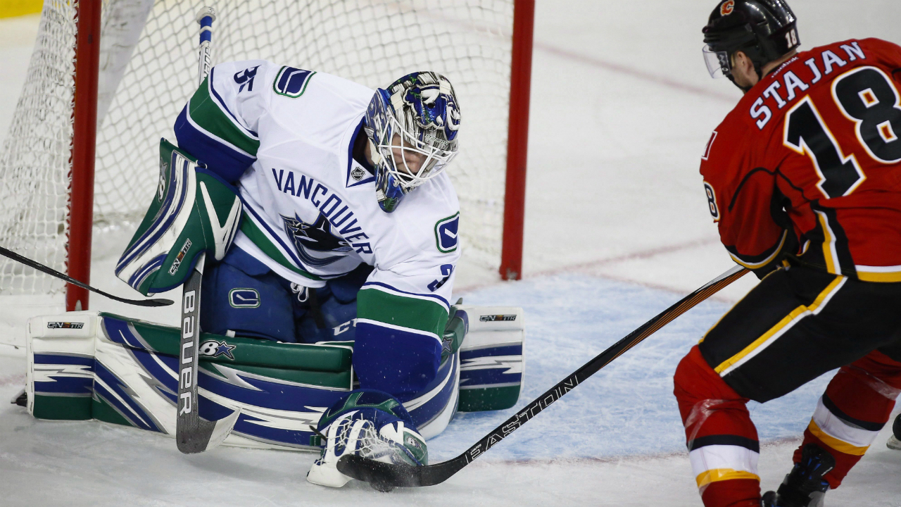 Vancouver-Canucks-goalie-Thatcher-Demko,-left,-grabs-the-puck-away-from-Calgary-Flames'-Matt-Stajan,-during-third-period-pre-season-NHL-hockey-action-in-Calgary,-Friday,-Sept.-30,-2016.THE-CANADIAN-PRESS/Jeff-McIntosh