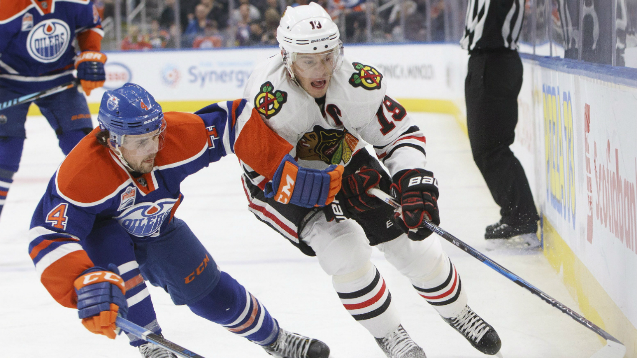 Chicago-Blackhawks'-Jonathan-Toews-(19)-and-Edmonton-Oilers'-Kris-Russell-(4)-battle-for-the-puck-during-third-period-NHL-action-in-Edmonton,-Alta.,-on-Monday-November-21,-2016.-(Jason-Franson/CP)