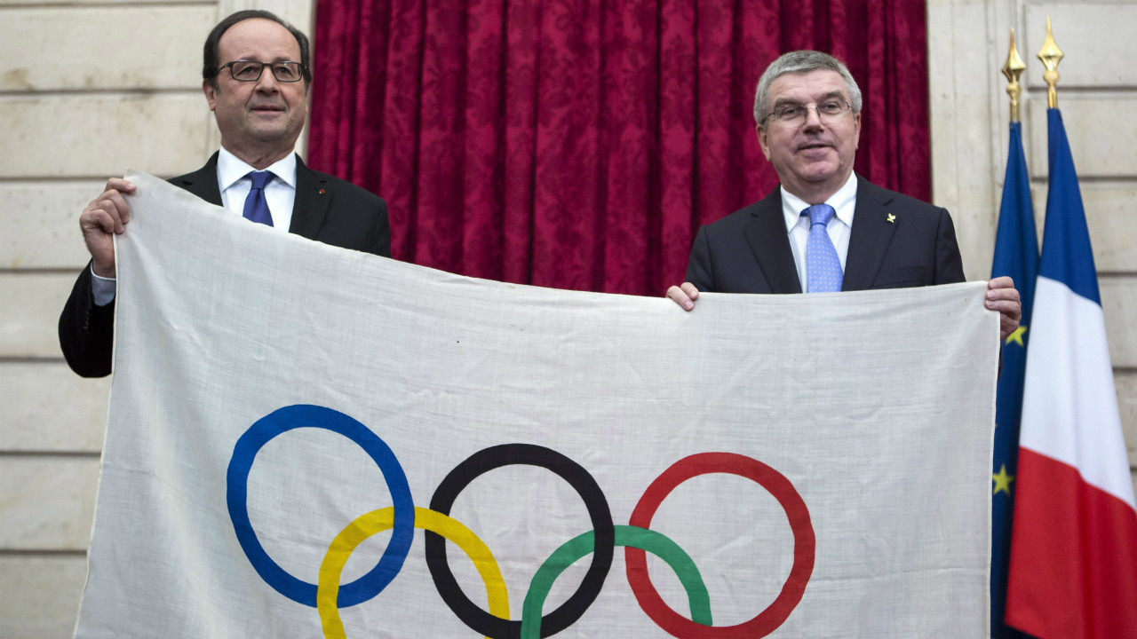 French-President-Francois-Hollande,-left,-and-International-Olympic-Committee-President-Thomas-Bach,-hold-a-1924-Olympics-games-flag-during-a-meeting-at-the-Elysee-Palace-in-Paris,-Sunday,-Oct.-2,-2016.-Paris,-which-last-hosted-the-Olympics-in-1924,-is-competing-against-Budapest,-Rome-and-Los-Angeles-for-the-games.-(Kamil-Zihnioglu,-Pool/AP)