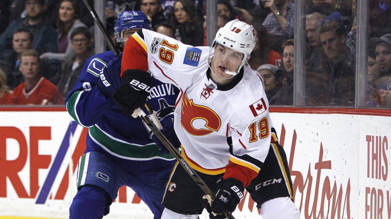 Calgary-Flames-left-wing-Matthew-Tkachuk-(19)-plays-the-puck-near-Vancouver-Canucks-defenceman-Christopher-Tanev-(8)-during-first-period-NHL-hockey-action-in-Vancouver-on-Saturday,-February-18,-2017.-(Ben-Nelms/CP)