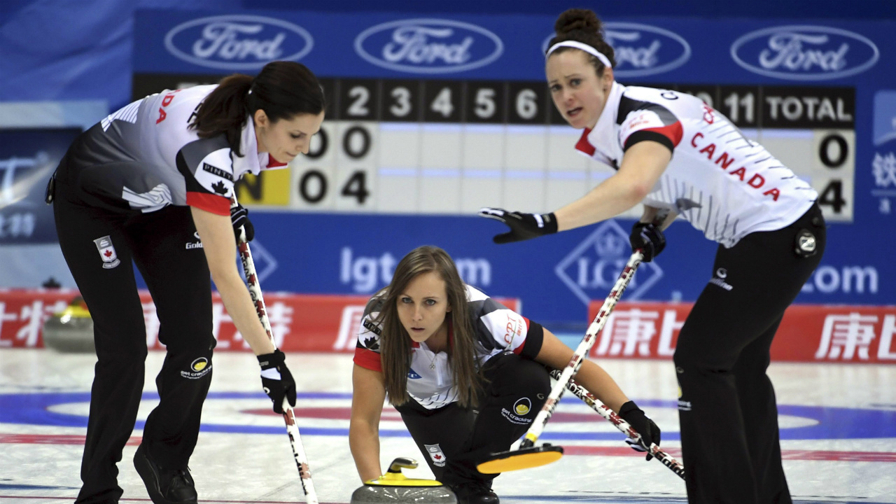 Rachel-Homan,-centre,-of-Canada-throws-a-curling-stone.-(Chinatopix-Via-AP)