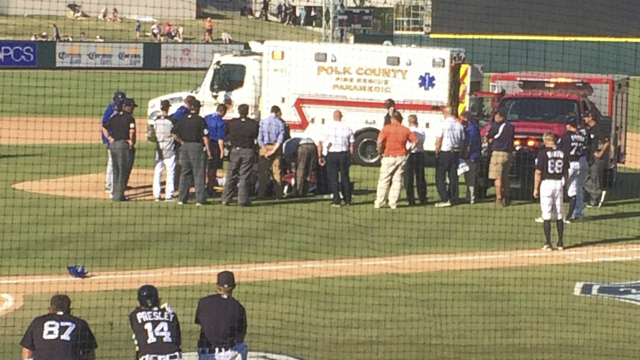 In-this-photo-provided-by-Nick-Brzezinski,-players-and-staff-watch-as-Toronto-Blue-Jays-reliever-T.J.-House-is-tended-to-by-emergency-personnel-after-he-was-struck-in-the-head-by-a-line-drive-during-a-spring-training-baseball-game-against-the-Detroit-Tigers,-Friday,-March-10,-2017,-in-Lakeland,-Fla.-(Nick-Brzezinski-via-AP)
