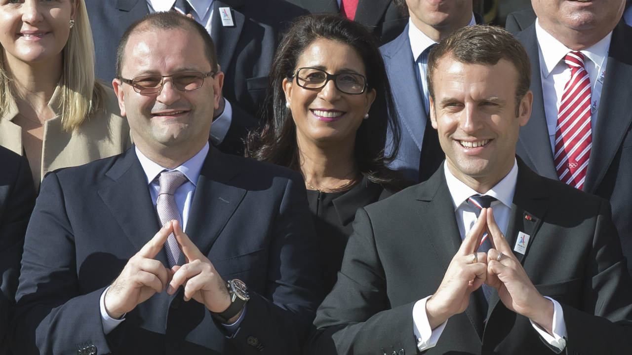 International Olympic Committee Evaluation Commission Chair Patrick Baumann, left, and new French President Emmanuel Macron make a singe representing the logo of Paris 2024 bid as they pose during a group photo at the Elysee palace in Paris, France, May 16, 2017. France's new President Emmanuel Macron is hosting the International Olympic Committee to try to boost Paris' bid to beat out Los Angeles in the heated race for the 2024 Games. (Michel Euler/AP)