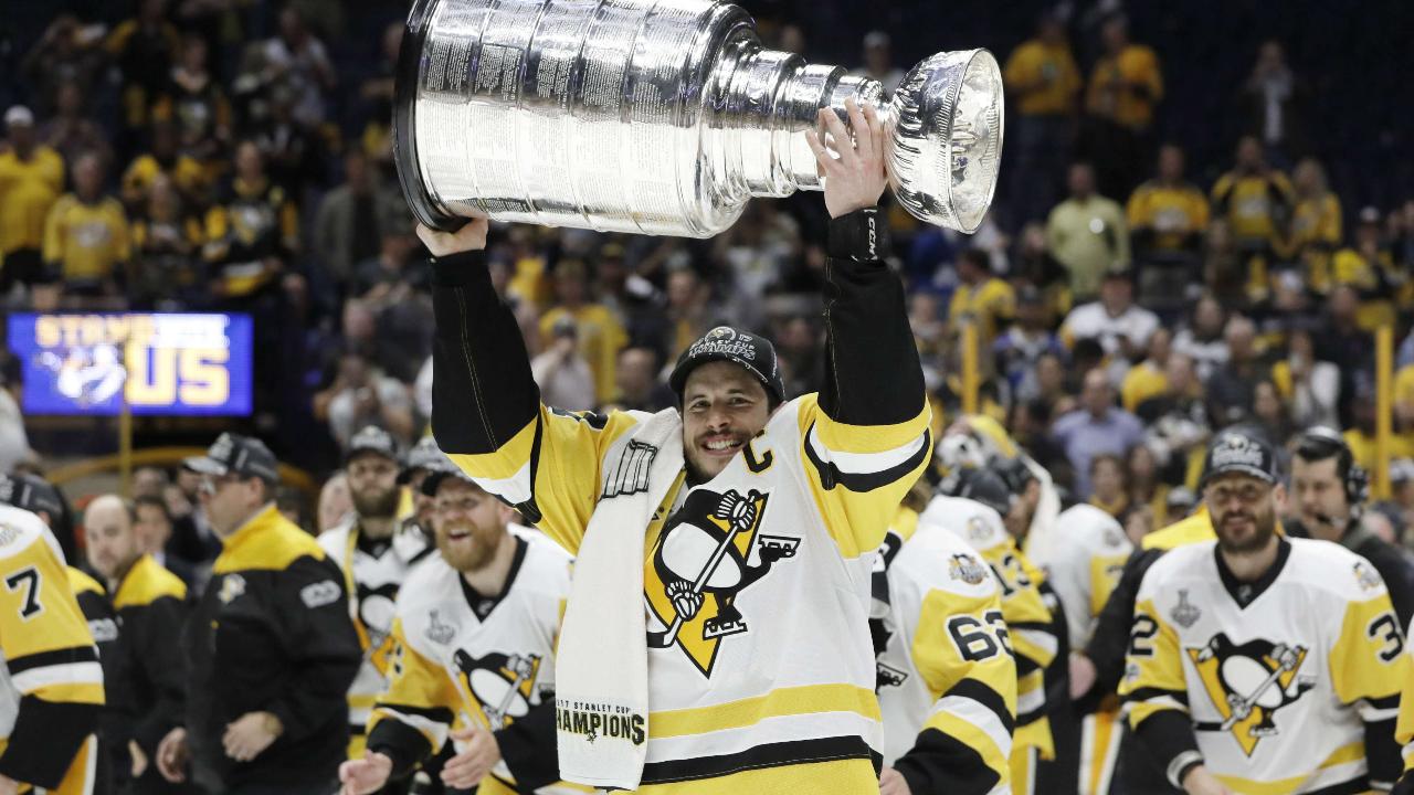 Pittsburgh Penguins center Sidney Crosby holds the Stanley Cup as fans  reach out to touch the trophy during the parade celebrating back to back Stanley  Cup victory in Pittsburgh on June 14