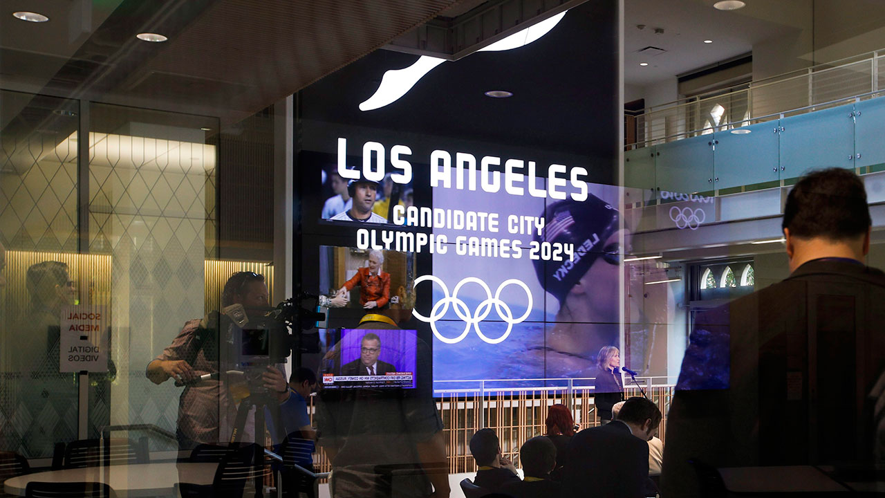 Journalists-listen-to-a-presentation-at-USC's-Wallis-Annenberg-Hall,-Los-Angeles-2024's-proposed-site-for-the-main-press-center,-Thursday,-May-11,-2017,-in-Los-Angeles.-After-bidding-for-the-2024-Olympics,-Los-Angeles-might-have-to-wait.-With-the-competition-down-to-LA-and-Paris,-IOC-leaders-are-considering-a-proposal-to-award-the-next-two-Olympics,-2024-and-2028,-one-to-each-city.-[Jae-C.-Hong/AP}