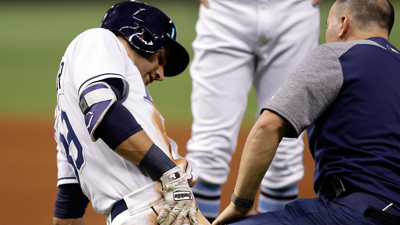 Tampa-Bay-Rays'-Kevin-Kiermaier,-left,-is-helped-by-team-trainer-Ron-Porterfield-after-injuring-his-leg-sliding-into-first-base-during-the-fifth-inning-of-a-baseball-game-against-the-Chicago-White-Sox-on-Thursday,-June-8,-2017,-in-St.-Petersburg,-Fla.-Kiermaier-left-the-game.-(Chris-O'Meara/AP)