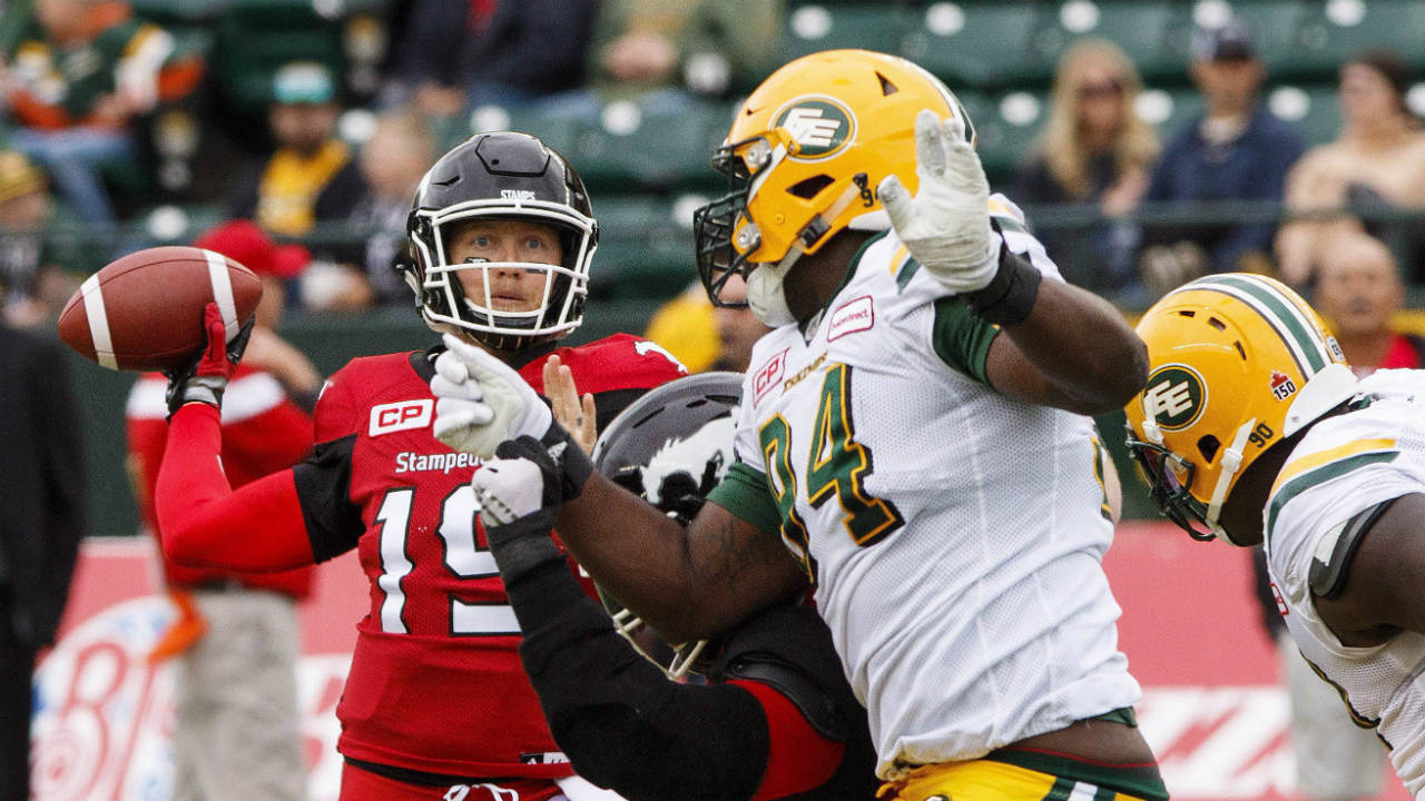 Calgary-Stampeders-quarterback-Bo-Levi-Mitchell-(19)-under-pressure-from-Edmonton-Eskimos-Euclid-Cummings-(94)-during-first-half-CFL-pre-season-action-in-Edmonton,-Alta.,-on-Sunday-June-11,-2017.-(Amber-Bracken/CP)