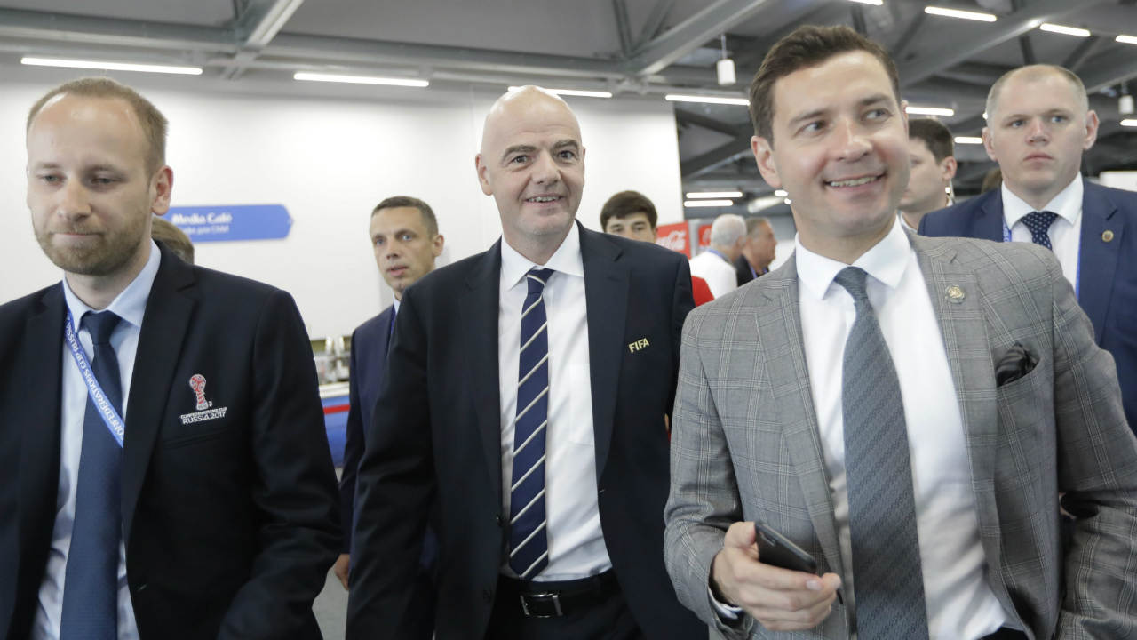 Surrounded-by-officials-FIFA-President-Gianni-Infantino,-third-from-left,-seen-during-his-visit-to-Media-centre-prior-the-Group-A-soccer-match-between-Portugal-and-Mexico,-at-the-Kazan-Arena,-Russia,-Sunday,-June-18,-2017.-(Sergei-Grits/AP)