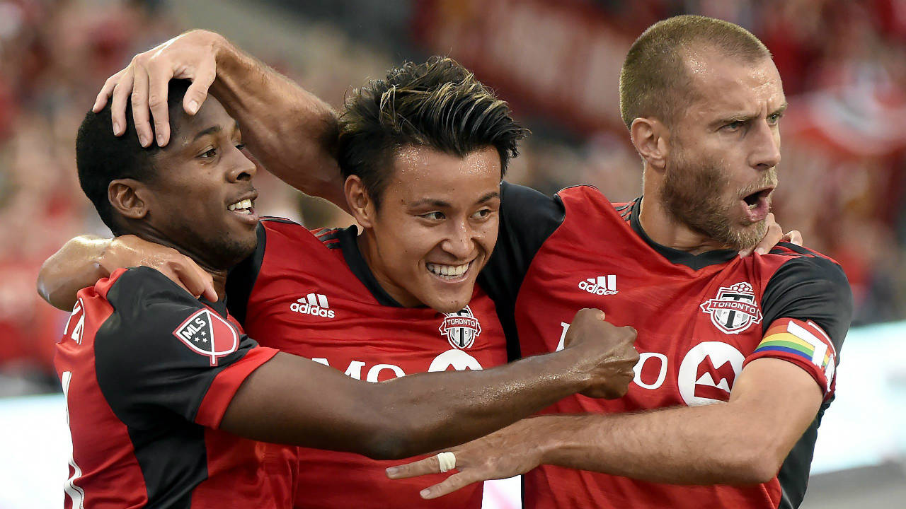 Toronto-FC's-Armando-Cooper,-left,-and-teammate-Tsubasa-Endoh-celebrate-their-assist-on-a-goal-by-teammate-Drew-Moor,-not-shown,-with-Benoit-Cheyrou,-right,-during-first-half-MLS-soccer-action-against-the-New-England-Revolution,-in-Toronto-on-Friday,-June-23,-2017.-(Nathan-Denette/CP)