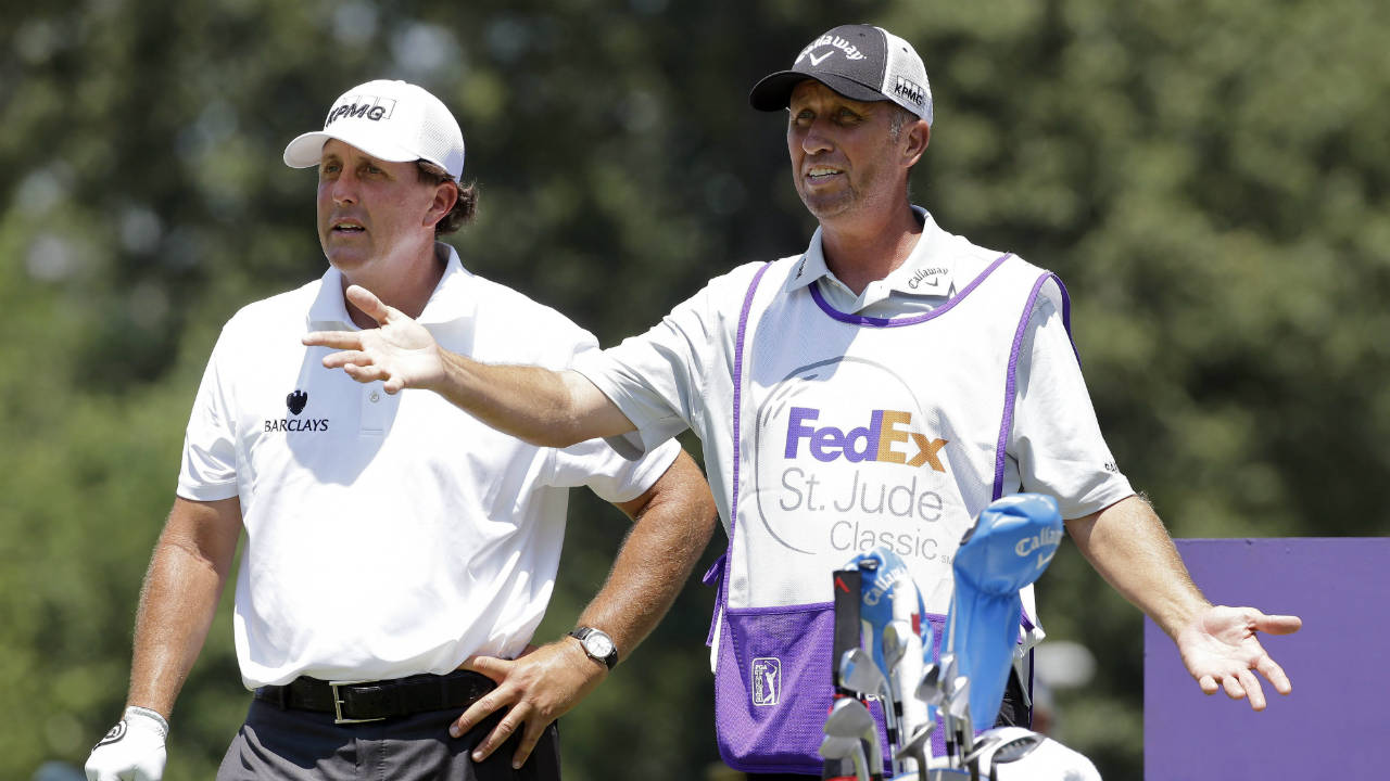 In-this-June-11,-2015,-file-photo,-Phil-Mickelson,-left,-talks-with-his-caddie-Jim-Mackay-on-the-eighth-tee-during-the-first-round-of-the-St.-Jude-Classic-golf-tournament-in-Memphis,-Tenn.-Mickelson-and-his-caddie-have-decided-to-part-ways-after-25-years-of-one-of-the-most-famous-player-caddie-relationships-on-the-PGA-Tour.-Mickelson-and-Jim-"Bones"-Mackay-say-the-decision-to-split-was-mutual-and-not-based-on-an-incident.-(Mark-Humphrey,-File/AP)