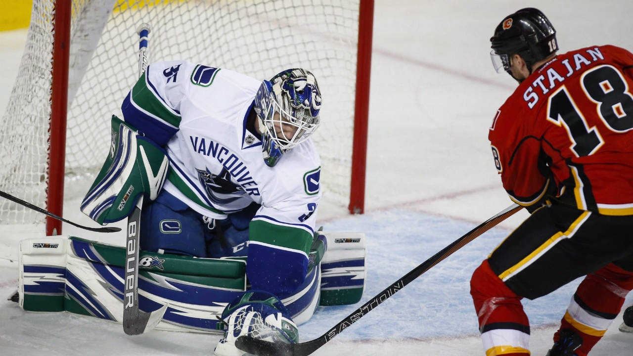 Vancouver-Canucks-goalie-Thatcher-Demko,-left,-grabs-the-puck-away-from-Calgary-Flames'-Matt-Stajan,-during-third-period-pre-season-NHL-hockey-action-in-Calgary,-Friday,-Sept.-30,-2016.-(Jeff-McIntosh/CP)