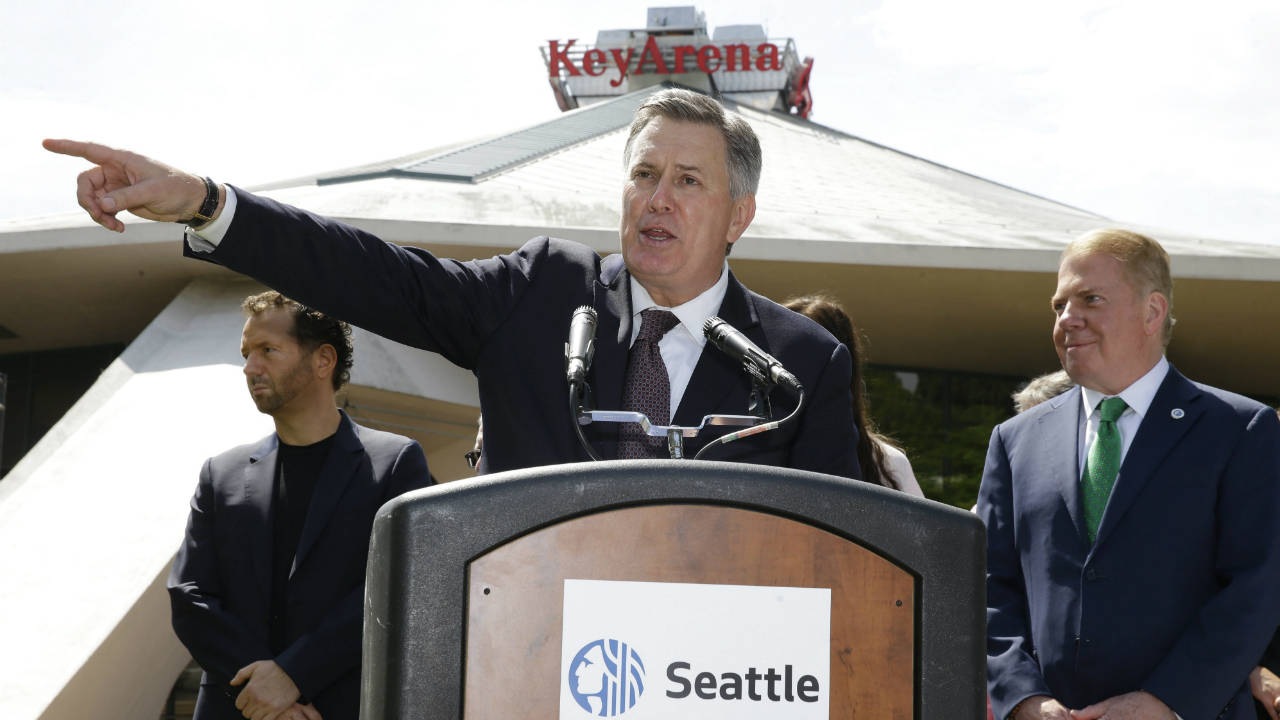 Tim-Leiweke,-CEO-of-the-Oak-View-Group,-centre,-speaks-during-a-news-conference-as-Seattle-Mayor-Ed-Murray-looks-on-at-right-on-Wednesday,-June-7,-2017,-in-front-of-KeyArena-in-Seattle.-Murray-said-the-city-will-enter-into-negotiations-with-the-Oak-View-Group-on-a-proposal-for-a-privately-financed-renovation-of-the-city-owned-KeyArena.-Plans-for-the-remodel-would-bring-the-building-up-to-standards-that-could-attract-an-NHL-or-NBA-franchise-once-completed.-(Ted-S.-Warren/AP)