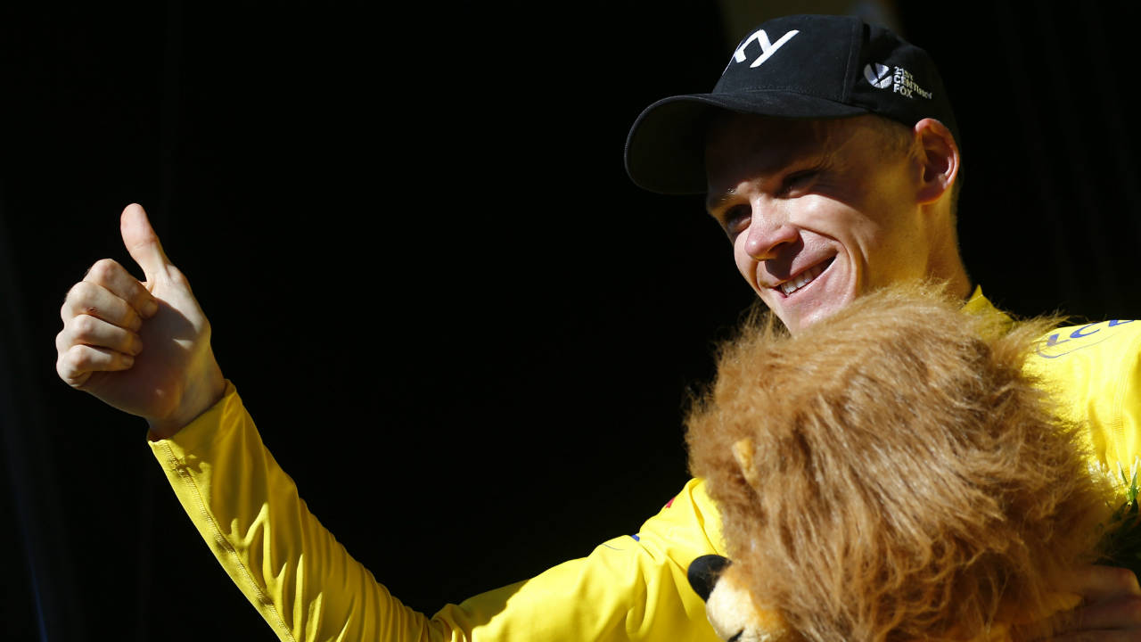 Britain's-Chris-Froome,-wearing-the-overall-leader's-yellow-jersey,-flashes-a-thumbs-up-as-he-celebrates-on-the-podium-after-the-fourteenth-stage-of-the-Tour-de-France-cycling-race-over-181.5-kilometers-(112.8-miles)-with-start-in-Blagnac-and-finish-in-Rodez,-France,-Saturday,-July-15,-2017.-(Peter-Dejong/AP)