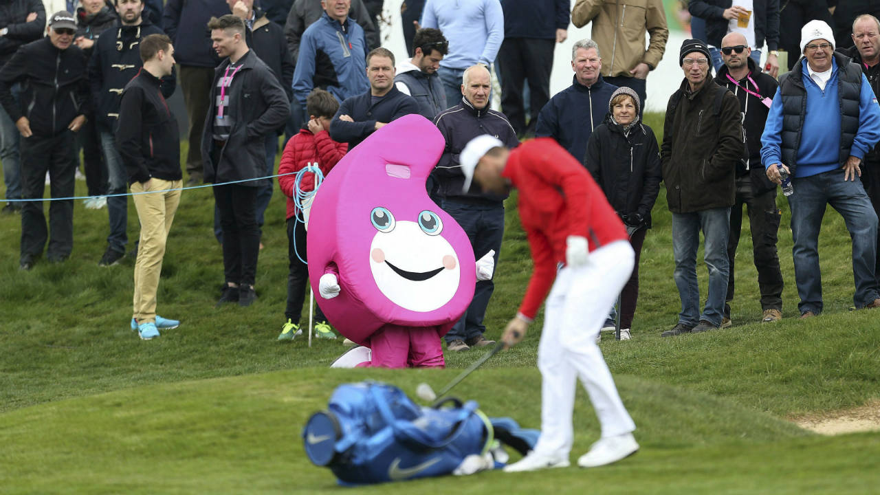 A-mascot-is-displayed-as-Denmark's-Lucas-Bjerregaard-prepares-to-make-a-shot,-during-day-one-of-the-Golf-Sixes-at-the-Centurion-Club,-in-St-Albans,-England,-Saturday-May-6,-2017.-The-European-Tour-rolls-out-its-latest-innovative-tournament,-the-six-hole-GolfSixes-event-featuring-two-man-teams-from-16-different-countries.-(Steven-Paston/PA-via-AP)