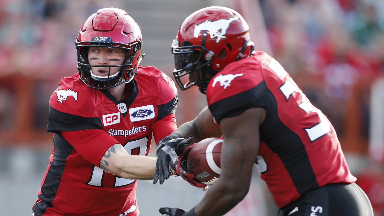 Calgary-Stampeders-quarterback-Bo-Levi-Mitchell,-left,-hands-off-to-Jerome-Messam-during-first-half-CFL-football-action-against-the-Saskatchewan-Roughriders-in-Calgary-on-Saturday-July-22,-2017.-(Larry-MacDougal/CP)