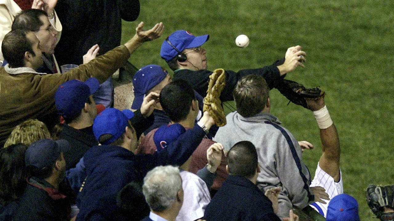 In-this-Oct-14,-2003,-file-photo,-Steve-Bartman-catches-a-ball-as-Chicago-Cubs-left-fielder-Moises-Alou's-arm-is-seen-reaching-into-the-stands,-at-right,-against-the-Florida-Marlins-in-the-eighth-inning-during-Game-6-of-the-National-League-championship-series-Tuesday,-Oct.-14,-2003,-at-Wrigley-Field-in-Chicago.-(Morry-Gash,-File/AP)