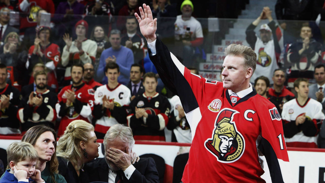 Former-Ottawa-Senators-player-Daniel-Alfredsson-makes-his-way-to-the-ice-as-his-father-Hasse-Alfredsson-(centre)-is-comforted-by-his-daughter-Cecelia-Sable-as-Alfredsson's-wife-Birgitta-and-son-Fenix-look-on-during-a-ceremony-retiring-Alfredsson's-Senators-jersey-number-11-in-Ottawa,-Thursday-December-29,-2016.-(Fred-Chartrand/CP)