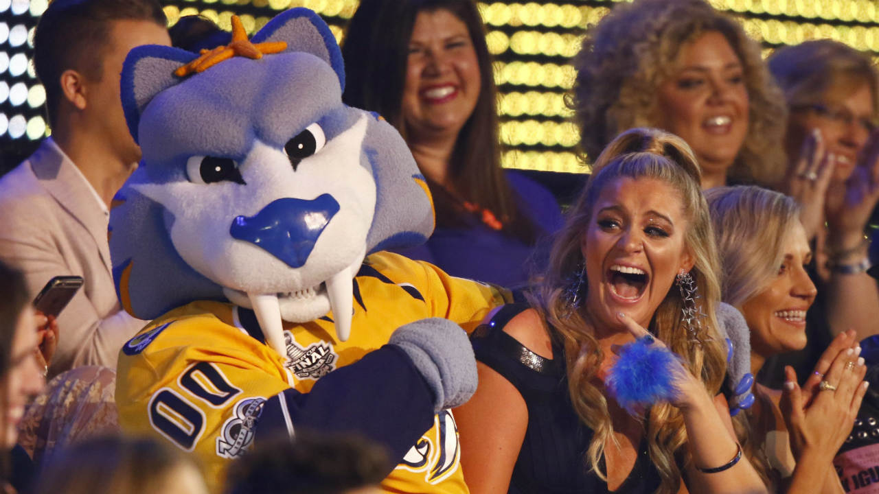 Lauren-Alaina-sits-in-the-audience-with-Gnash,-the-mascot-for-the-NHL's-Nashville-Predators.-(Photo-by-Wade-Payne/Invision/AP)