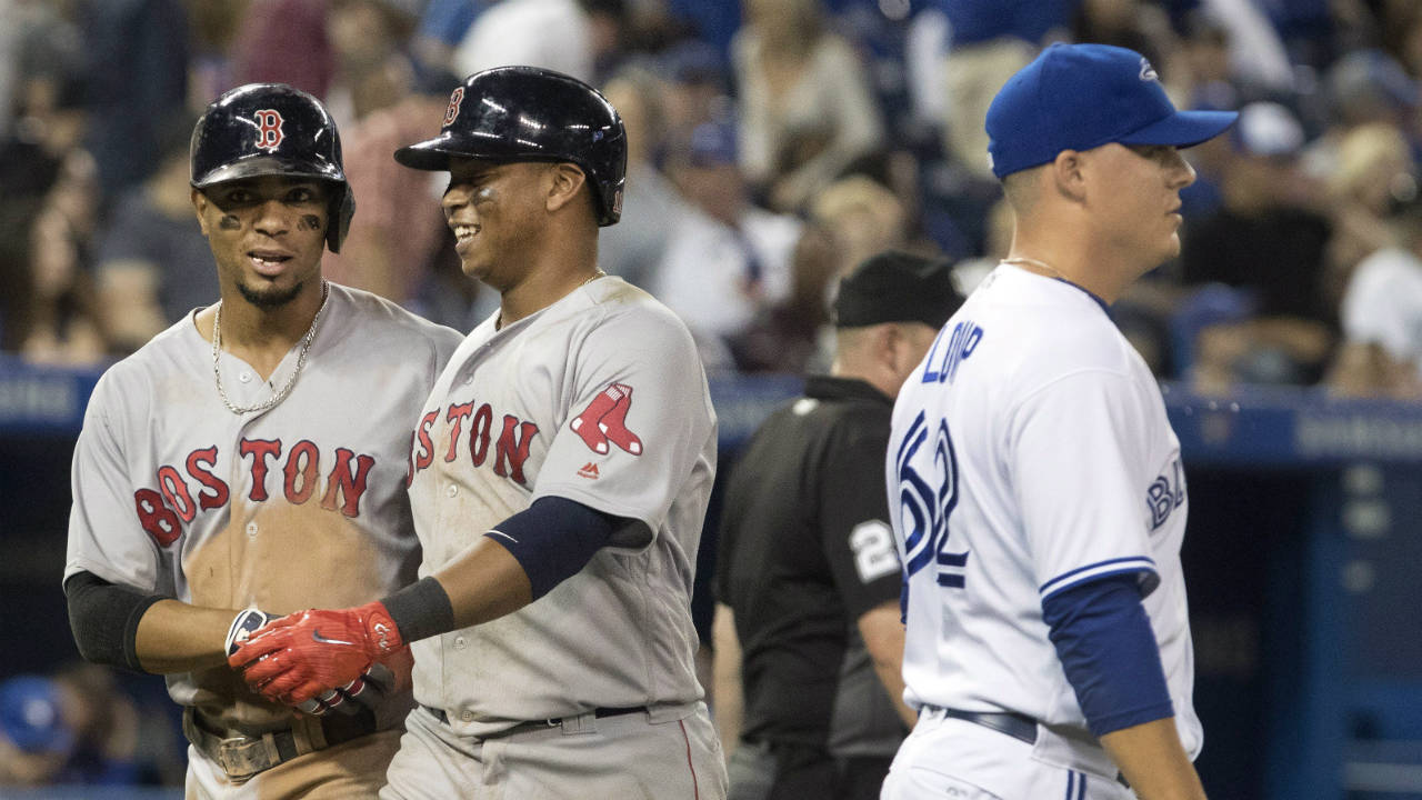 Boston-Red-Sox'-Rafael-Devers,-centre,-and-Xander-Bogaerts,-left,-come-into-score-behind-Toronto-Blue-Jays-pitcher-Aaron-Loup-in-the-eighth-inning-of-their-American-League-MLB-baseball-game-in-Toronto-on-Wednesday-August-30,-2017.-(Fred-Thornhill/CP)