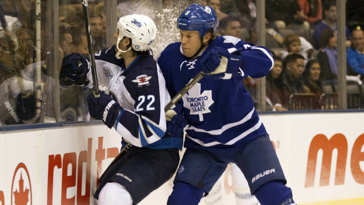 Toronto-Maple-Leafs-defenceman-Mike-Komisarek-(right)-takes-Winnipeg-Jets'-Chris-Thorburn-(22)-into-the-boards-first-period-NHL-action-in-Toronto-on-Wenesday-October-19,-2011.-(Frank-Gunn/CP)