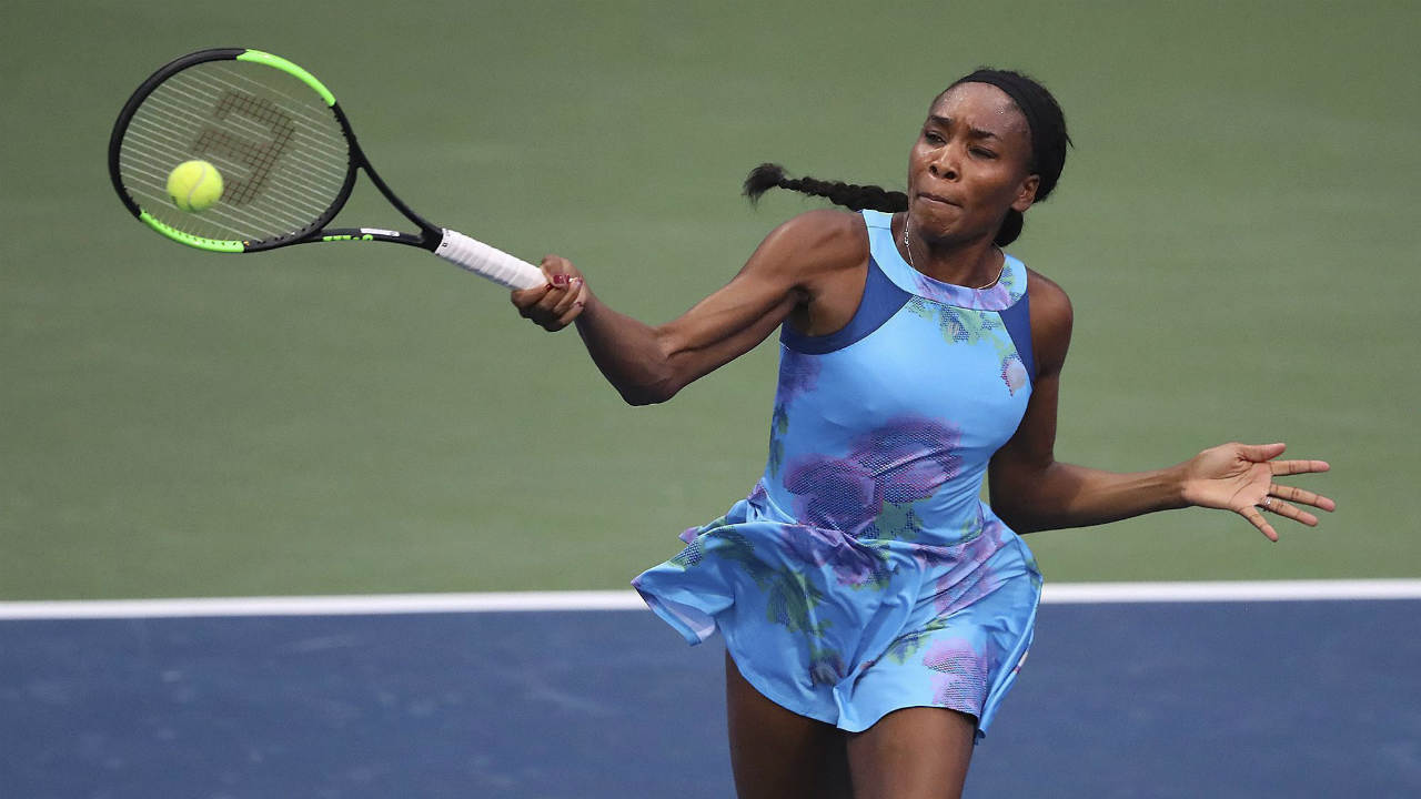 Venus-Williams-returns-to-Canada's-Genie-Bouchard-in-a-special-women's-exhibition-tennis-match-at-the-BB&T-Atlanta-Open-Tournament,-Sunday,-July-23,-2017,-in-Atlanta.-(Curtis-Compton/Atlanta-Journal-Constitution-via-AP)