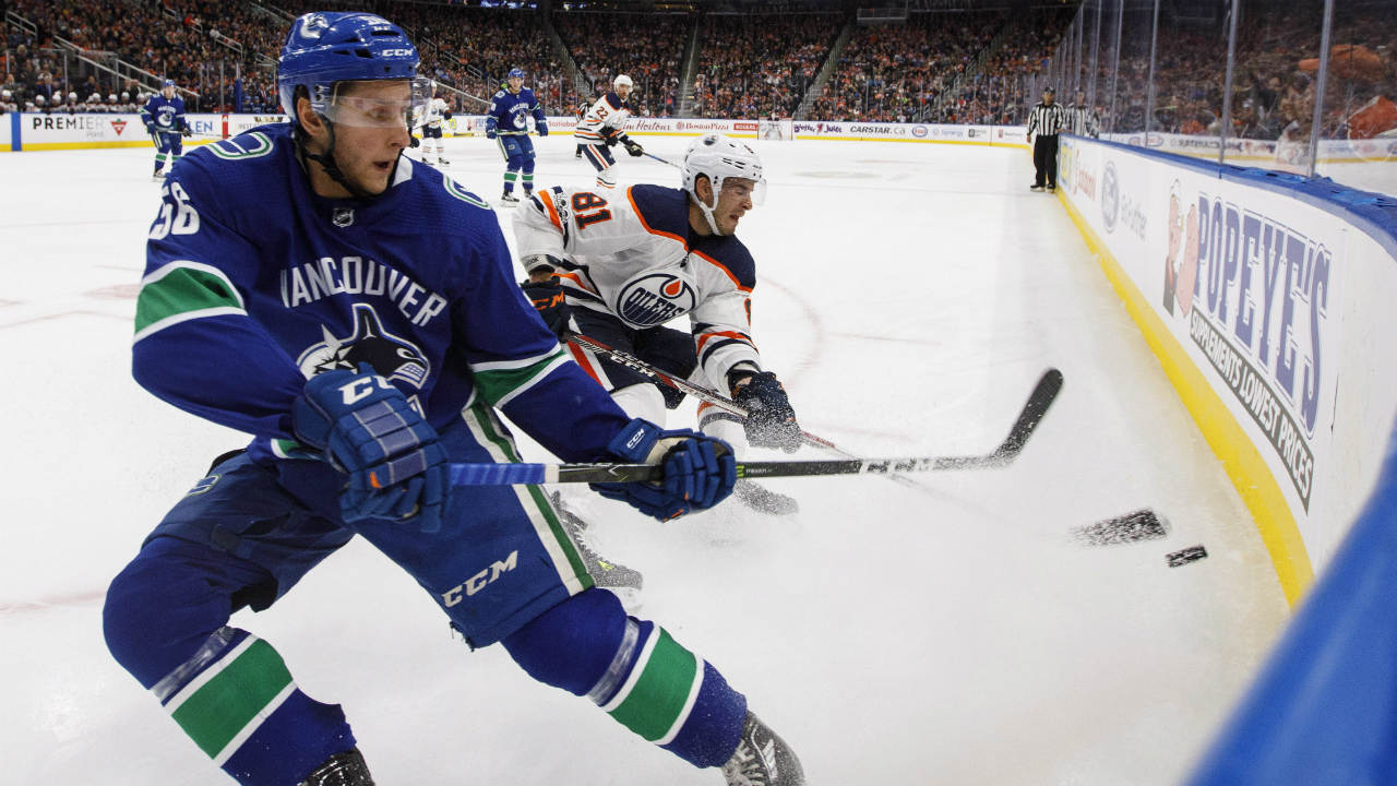 Vancouver-Canucks'-Guillaume-Brisebois-(56)-and-Edmonton-Oilers'-Yohann-Auvitu-(81)-battle-for-the-puck-during-second-period-pre-season-NHL-action-in-Edmonton,-Alta.,-on-Friday-September-22,-2017.-(Jason-Franson/CP)