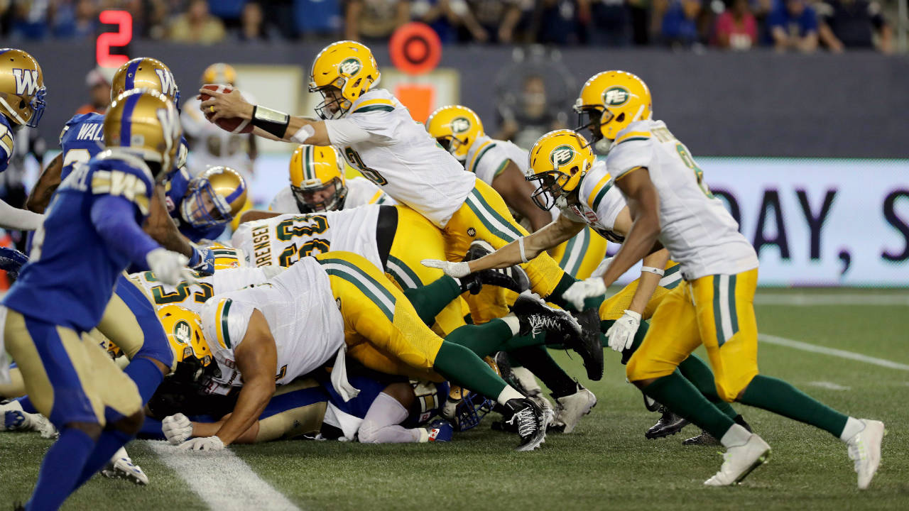 Edmonton-Eskimos-quarterback-Mike-Reilly-(13)-dives-for-a-touchdown-while-playing-against-the-Winnipeg-Blue-Bombers-during-the-second-half-of-CFL-football-action-in-Winnipeg,-Thursday,-August-17,-2017.-(Trevor-Hagan/CP)