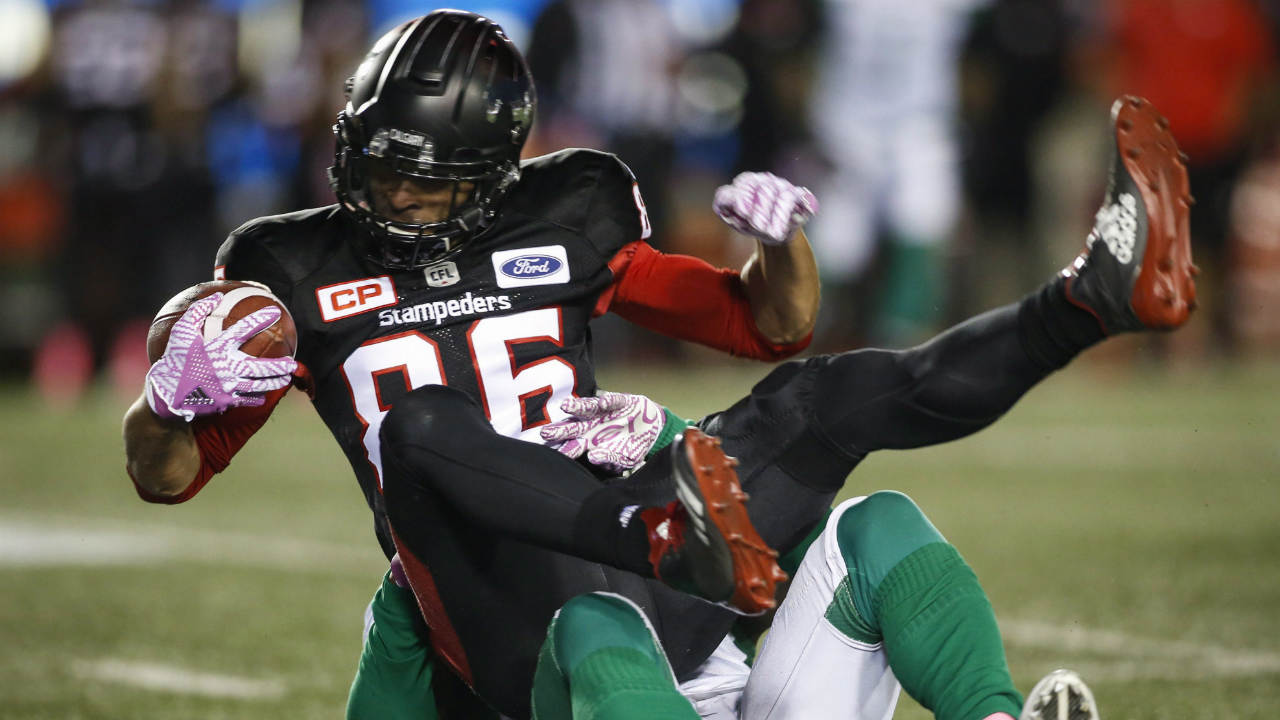 Saskatchewan-Roughriders'-Samuel-Eguavoen,-bottom,-tackles-Calgary-Stampeders'-Anthony-Parker-during-first-half-CFL-football-action-in-Calgary,-Friday,-Oct.-20,-2017.-(Jeff-McIntosh/CP)