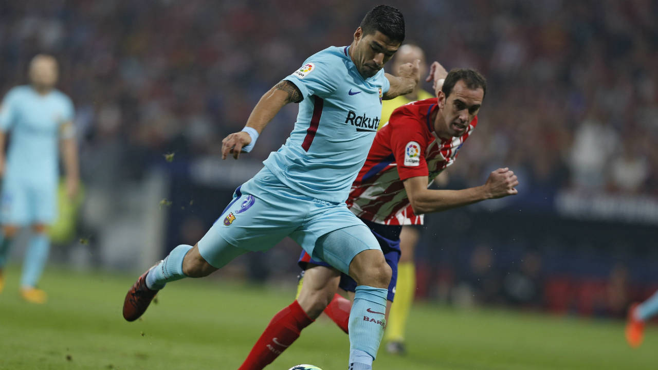 Barcelona's-Luis-Suarez,-front,-shoots-the-ball-next-to-Atletico-Madrid's-Diego-Godin-during-a-Spanish-La-Liga-soccer-match-between-Atletico-Madrid-and-Barcelona-at-the-Metropolitano-stadium-in-Madrid,-Saturday,-Oct.-14,-2017.-Suarez-scored-once-and-the-match-ended-in-a-1-1-draw.-(Francisco-Seco/AP)