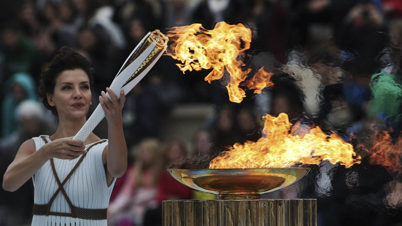 Actress-Katerina-Lehou-playing-the-role-of-high-priestess-lights-an-Olympic-torch-during-a-handover-ceremony-for-the-Olympic-Flame-at-Panathenaic-stadium-in-Athens,-on-Tuesday,-Oct.-31,-2017.-The-South-Korean-leg-of-the-relay-will-involve-7,500-torch-bearers,-who-will-cover-a-total-2,018-kilometers-(about-1260-miles)-before-the-opening-ceremony-in-Pyeongchang,-which-will-host-the-Feb.-9-25,-2018-Winter-Olympics.-(Petros-Giannakouris/AP)