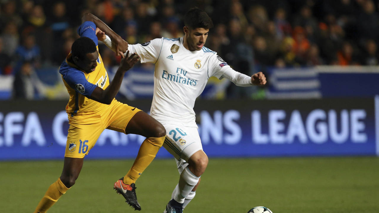 Real-Madrid's-Marco-Asensio,-right,-and-APOEL's-Vinicius-challenge-for-the-ball-during-the-Champions-League-Group-H-soccer-match-between-APOEL-Nicosia-and-Real-Madrid-at-GSP-stadium,-in-Nicosia,-on-Tuesday,-Nov.-21,-2017.-(Petros-Karadjias/AP)