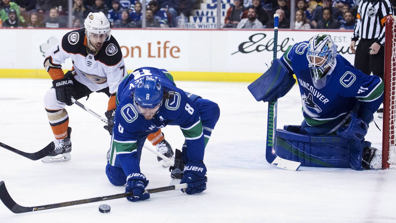 Vancouver-Canucks-defenceman-Christopher-Tanev-(8)-gets-the-puck-away-from-Anaheim-Ducks-left-wing-Andrew-Cogliano-(7)-as-Vancouver-Canucks-goaltender-Anders-Nilsson-(31)-looks-on-during-first-period-NHL-action-in-Vancouver,-Tuesday,-Jan.-2,-2018.-(Jonathan-Hayward/CP)