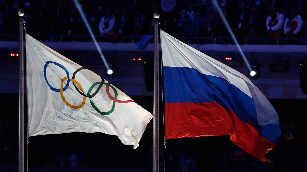 The Russian national flag, right, flies next to the Olympic flag. (Matthias Schrader/AP)