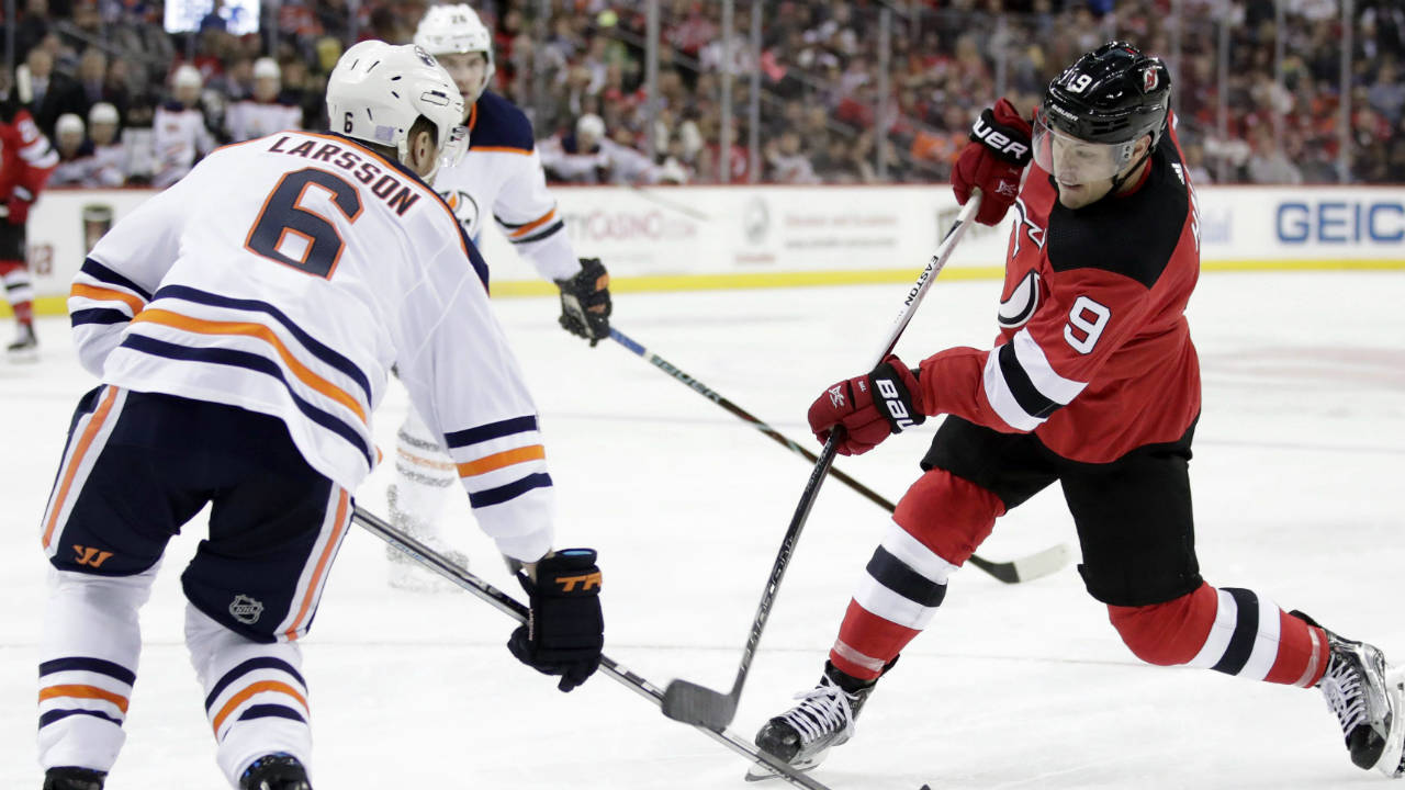 New-Jersey-Devils-left-wing-Taylor-Hall-(9)-takes-a-shot-as-Edmonton-Oilers-defenceman-Adam-Larsson-(6),-of-Sweden,-tries-to-block-it-during-the-second-period-of-an-NHL-hockey-game,-Thursday,-Nov.-9,-2017,-in-Newark,-N.J.-(Julio-Cortez/AP)