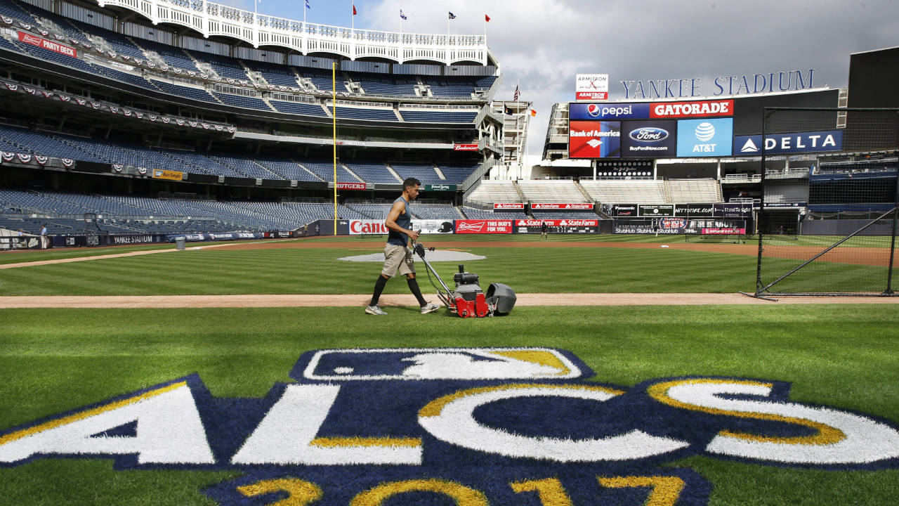 A-groundskeeper-mows-the-grass-around-a-recently-painted-field-logo-before-an-American-League-Championship-Series-baseball-workout-day-at-Yankee-Stadium-in-New-York,-Sunday,-Oct.-15,-2017.-(Kathy-Willens/AP)