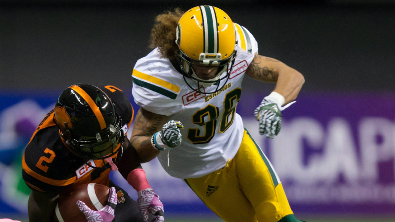 B.C.-Lions'-Chris-Rainey-(2)-is-taken-down-by-Edmonton-Eskimos'-Aaron-Grymes,-top-right,-and-Adam-Konar-during-the-first-half-of-a-CFL-football-game-in-Vancouver,-B.C.,-on-Saturday-October-21,-2017.-(Darryl-Dyck/CP)